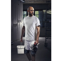 Meseriaș cu tricou, pantaloni scurți, găleată și gletieră pe un șantier