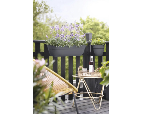 Scenă de balcon cu jardinieră plantată și decorațiuni pe o măsuță.