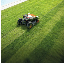 Un robot de tuns iarba tunde un gazon.