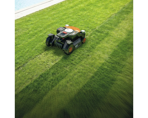 Un robot de tuns iarba tunde un gazon.