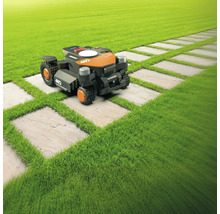 O mașină de tuns iarba robotizată pe un gazon