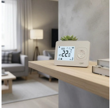 Termostat digital de cameră pe un raft într-un living pentru controlul temperaturii.