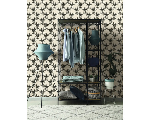 Exemplu de amenajare cu suport pentru haine, lampadar și tapet cu model pentru o ambianță stilată.