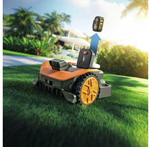 Robot de tuns iarba Worx cu baterie pe gazon în fața casei