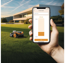 O mașină de tuns iarba robotizată pe un gazon este controlată printr-o aplicație de smartphone.