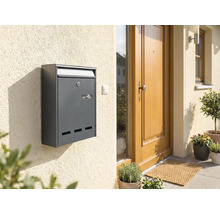 Cutie poștală antracit pe un perete al casei lângă o ușă de intrare