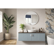 Baie luminoasă cu dulap de lavoar, oglindă rotundă și plante de interior.