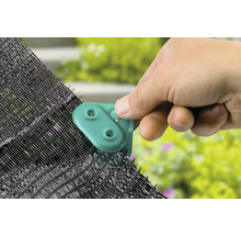 O mână atașează un clip de plasa de umbrire.