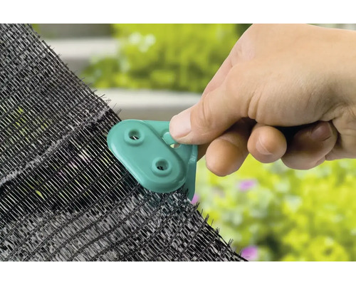 O mână atașează un clip de plasa de umbrire.