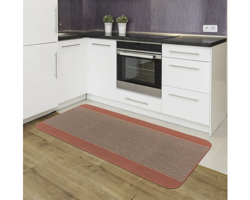 Covoraș de bucătărie în fața dulapurilor de bucătărie albe și un cuptor pe podea de lemn