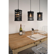 Trei lămpi suspendate negre deasupra unei mese de sufragerie aranjate.