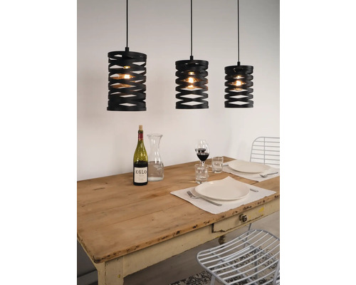 Trei lămpi suspendate negre deasupra unei mese de sufragerie aranjate.
