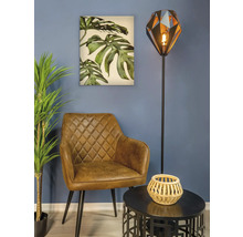 Scenă de living cu fotoliu, lampadar, masă și pictură murală