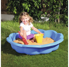 Copil se joacă într-o ladă cu nisip albastră cu jucării de nisip în grădină