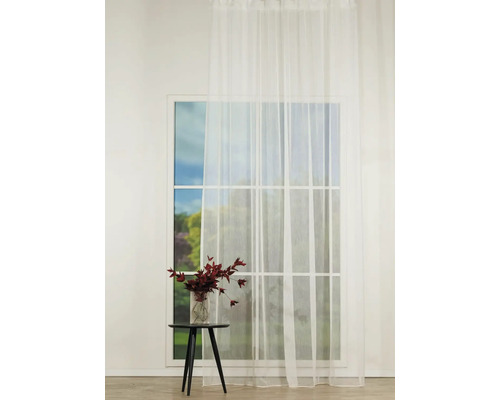 Scenă cu o draperie albă transparentă în fața unei ferestre, o măsuță și o vază cu flori.