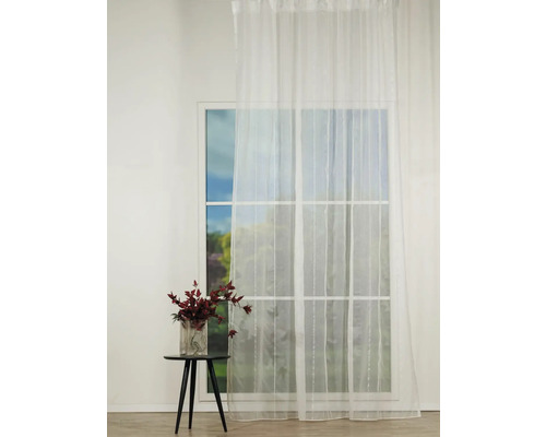 Fereastră cu perdea albă și măsuță cu vază