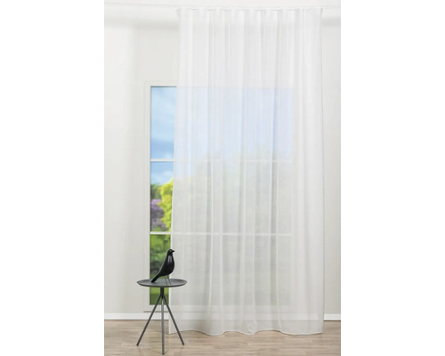 Cortină albă transparentă în fața unei ferestre cu o figurină decorativă pe o masă