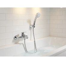 Baie cu cadă, robinet și duș de mână în fața plăcilor de perete