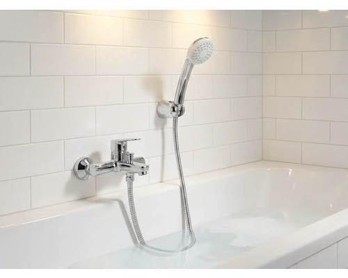 Baie cu cadă, robinet și duș de mână în fața plăcilor de perete