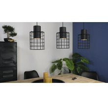 Trei lămpi suspendate cu cușcă de sârmă neagră deasupra unei mese de sufragerie într-o cameră luminoasă