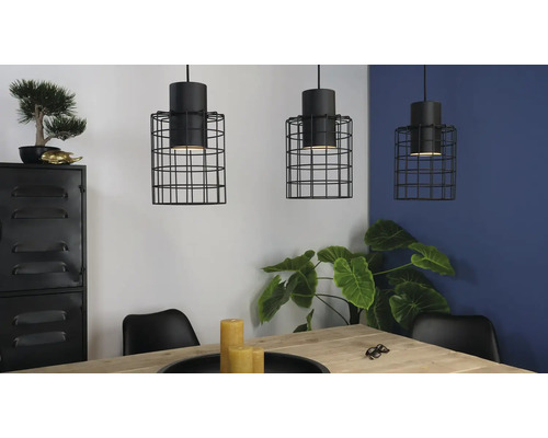 Trei lămpi suspendate cu cușcă de sârmă neagră deasupra unei mese de sufragerie într-o cameră luminoasă