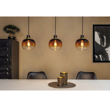 Scenă cu trei lămpi suspendate din sticlă deasupra unei mese de sufragerie