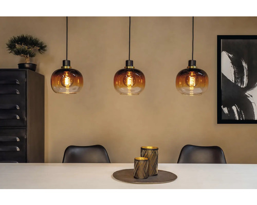 Scenă cu trei lămpi suspendate din sticlă deasupra unei mese de sufragerie