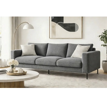 Canapea modernă cu trei locuri, cu material textil gri și picioare metalice subțiri, într-un living luminos și minimalist cu măsuță de cafea.