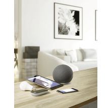 Imagine cu o cameră de zi cu dispozitive inteligente pentru casă, precum difuzoare, tablete, smartphone-uri și becuri pe o masă.