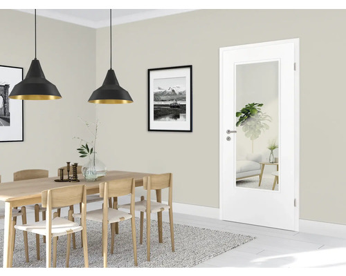 Sufragerie cu masă, scaune, lămpi suspendate și ușă interioară cu inserție de sticlă.