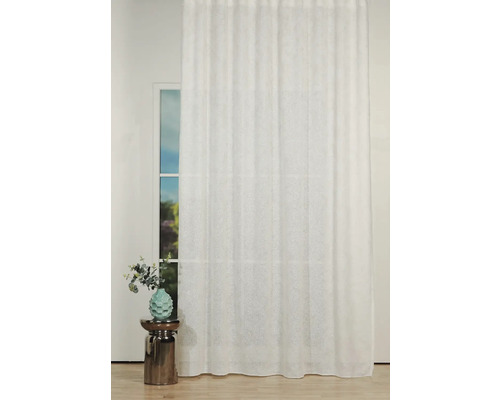 Laterala decorativă albă în fața unei ferestre, completată de o vază cu flori pe o măsuță laterală