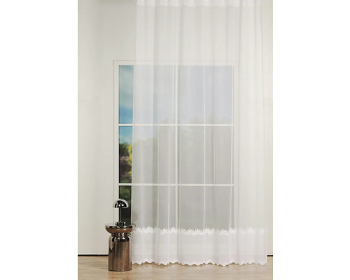 Fereastră cu perdea albă cu motiv de frunze