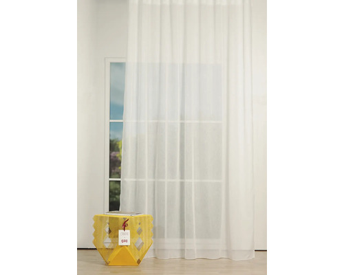 Scenă cu o cortină albă transparentă în fața unei ferestre și o măsuță laterală galbenă