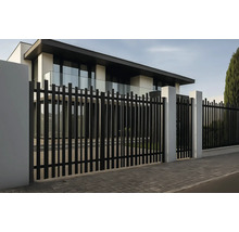 Gard metalic negru cu stâlpi albi în fața unei case moderne