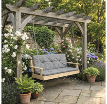 Scenă de grădină cu leagăn de lemn și pernă gri sub o pergolă, înconjurată de flori