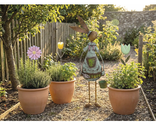 Scenă de grădină cu ghivece de teracotă plantate, suporturi pentru flori și un decor de grădină în formă de iepure