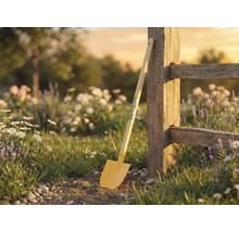 Scenă de grădină cu lopată sprijinită de gard din lemn