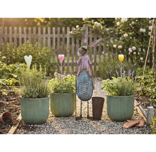 Scenă de grădină cu ghivece plantate, iepure metalic și decorațiuni pe o potecă de pietriș