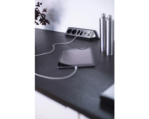 Bloc de prize cu porturi USB și tabletă conectată pe o masă