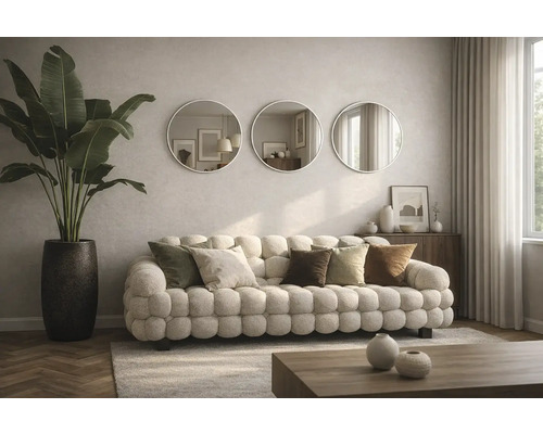 Living cu canapea, perne, oglinzi rotunde și plantă de apartament