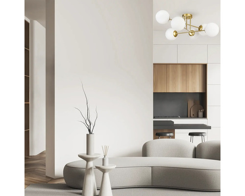 Amenajare interioară luminoasă cu canapea, mese și o lustră modernă.