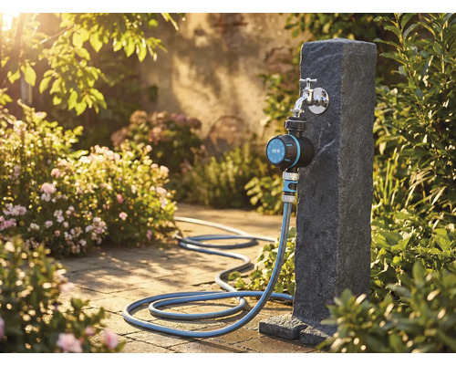 Scenă de grădină cu robinet de apă, programator de irigare și furtun de grădină