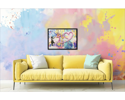 Canapea galbenă cu perne în fața unui perete cu o imagine încadrată a unei fete și a unei inimi