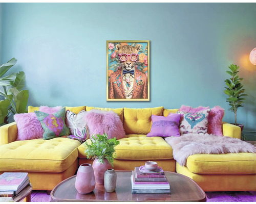 Living cu canapea de colț galbenă, perne și un tablou cu leopard înrămat pe perete