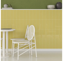 Scenă cu faianță galbenă, masă albă și scaune.