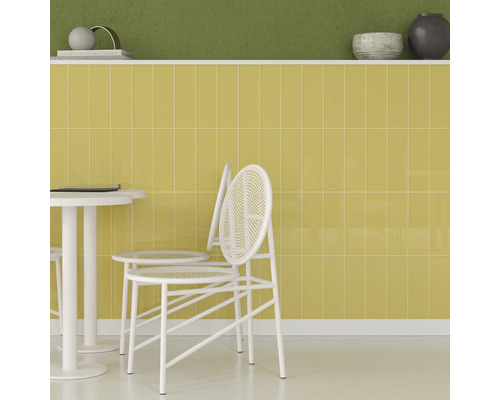 Scenă cu faianță galbenă, masă albă și scaune.