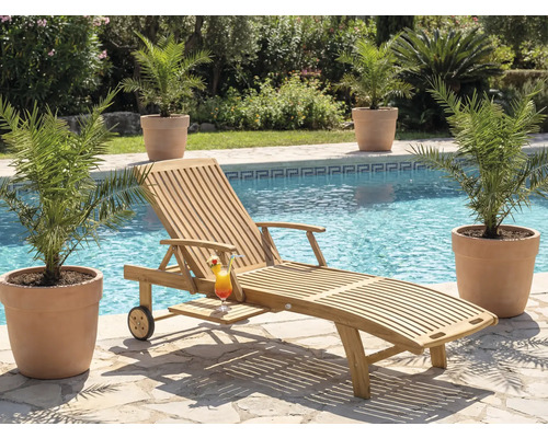 Scenă cu un șezlong din lemn, un cocktail și plante lângă o piscină.