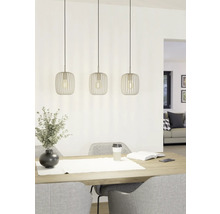 Trei lămpi suspendate metalice deasupra unei mese cu decorațiuni și scaune.