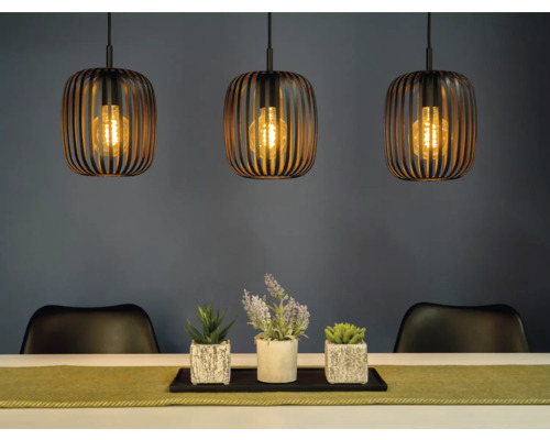 Scenă cu trei lămpi suspendate deasupra unei mese cu decorațiuni și scaune.