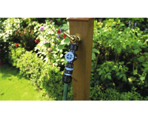 Scenă de grădină cu robinet pe stâlp de lemn și furtun de grădină conectat